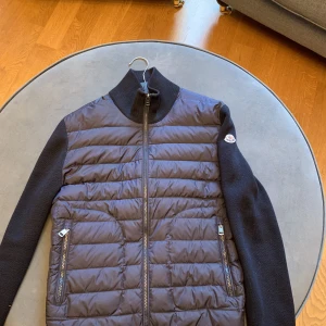Moncler cardigan  - Moncler cardigan i storlek M Fint skick bortsett från 2 hål men väldigt fin i övrigt!  Finns i centrala Stockholm 