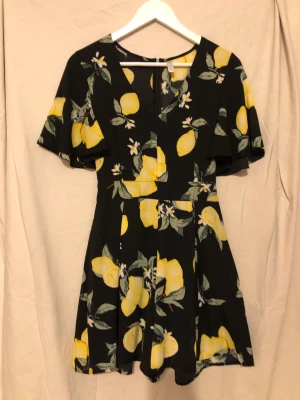 Playsuit citron - Playsuit- byxdress med citroner  V-ringad (Använd en gång)