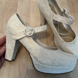 Klackskor i spets! - Super snygga klackskor i spets! Bandet Fästs med kardborre! Gulnat i färgen lite! Mer offwhite, aldrig använda! Skriv innan så fixar jag gratisfrakt 