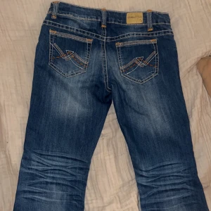 Lågmidjade jeans - Köpta i Köpenhamn på en second hand. Byxorna är lågmidjade och bootcut och har även vita och oranga sömmar som gör de unika. Jag är 1.78 och byxorna är någon cm kort för min smak