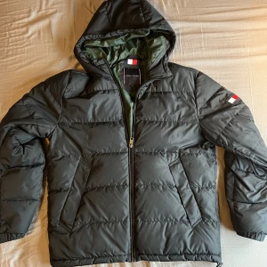 Tommy hilfiger jacka - En grå Tommy Hilfiger jacka. Funkar både vinter och vår.