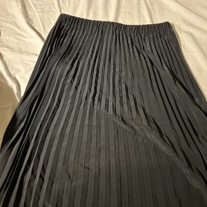 Kjol - Svart, knälång kjol i storlek M. Använd en gång.