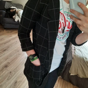 Kavaj strl XS - En rutig kavaj med uppvikta ärmar och två fickor