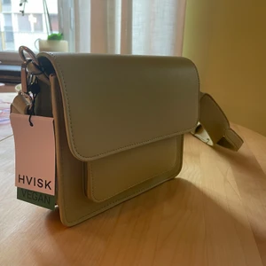 Green vegan Hvisk cross body bag  - Grön Hvisk väska, helt oanvänd med lappen kvar! Jätte fin men beställde fel och han inte lämna tillbaka och vill att den kommer till användning :) köpt för 850! Lägger till den rosa banden gratis, man kan ha den istället eller använda på andra väskor!