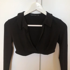 Croptop  - Svart stretchig croptop med krage från NLY one. Långa ärmar. 