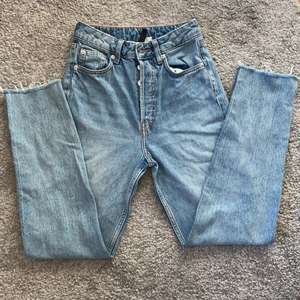 Divided H&M jeans - Ett par blåa högmidjade jeans med avklippta benslut osm är köpta på H&M, säljer då de tyvärr är för små! De är i storlek 32 (kontakta för exakta mått).  