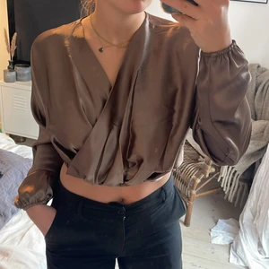 Satinblus - Satinblus i kort modell som är omlott framtill. Världens finaste tyg o färg!😍 Oanvänd med prislapp kvar. Från NaKd, storlek 36