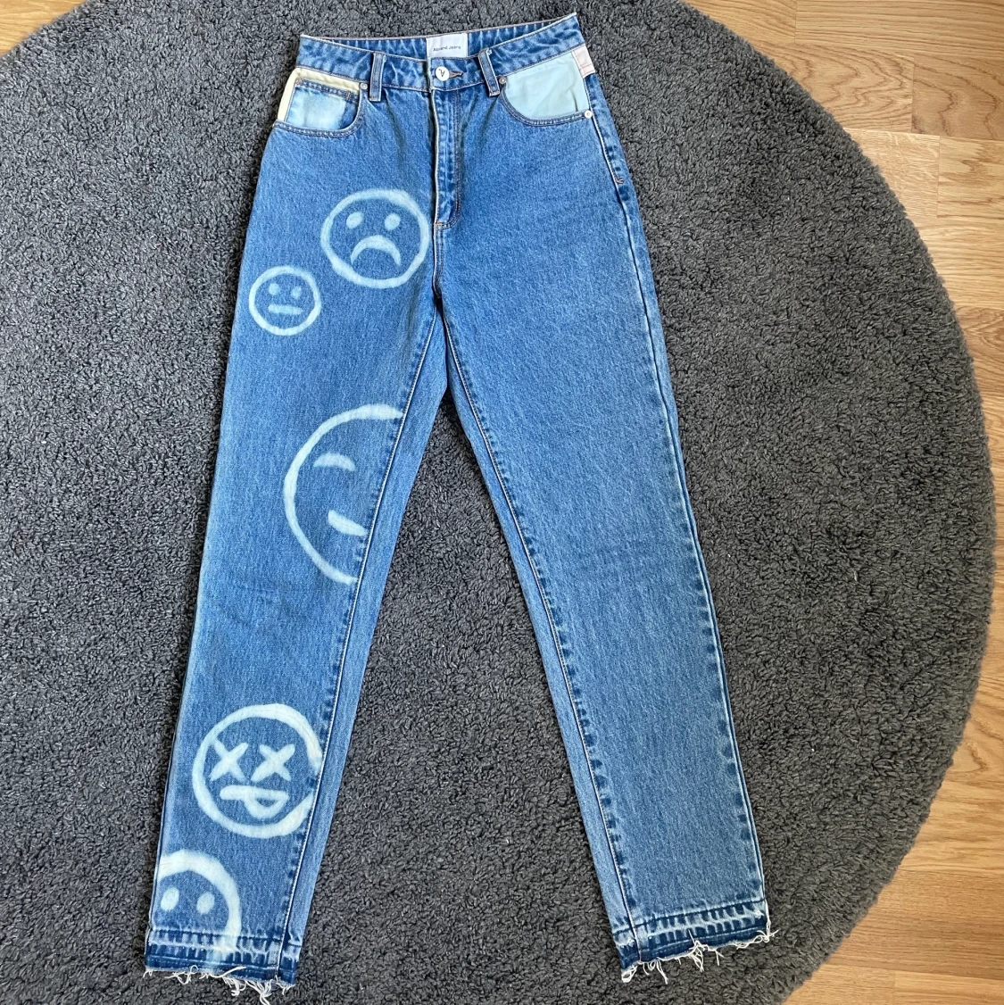 Jeans med blekta smileys på
