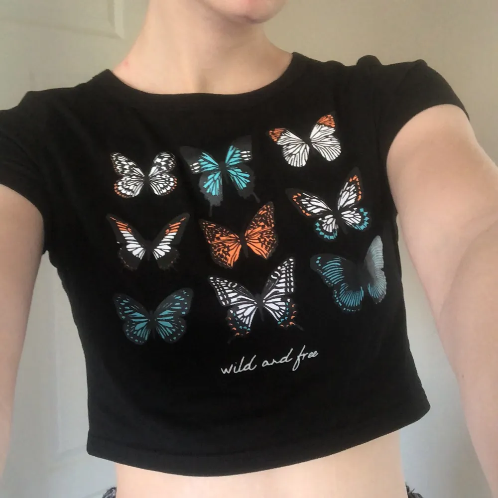 En kroppad svart T-shirt med fjärilar på från shein i strl S, använd typ 1 gång. 40 kr +frakt. Betalning via swish💜💜. Toppar.