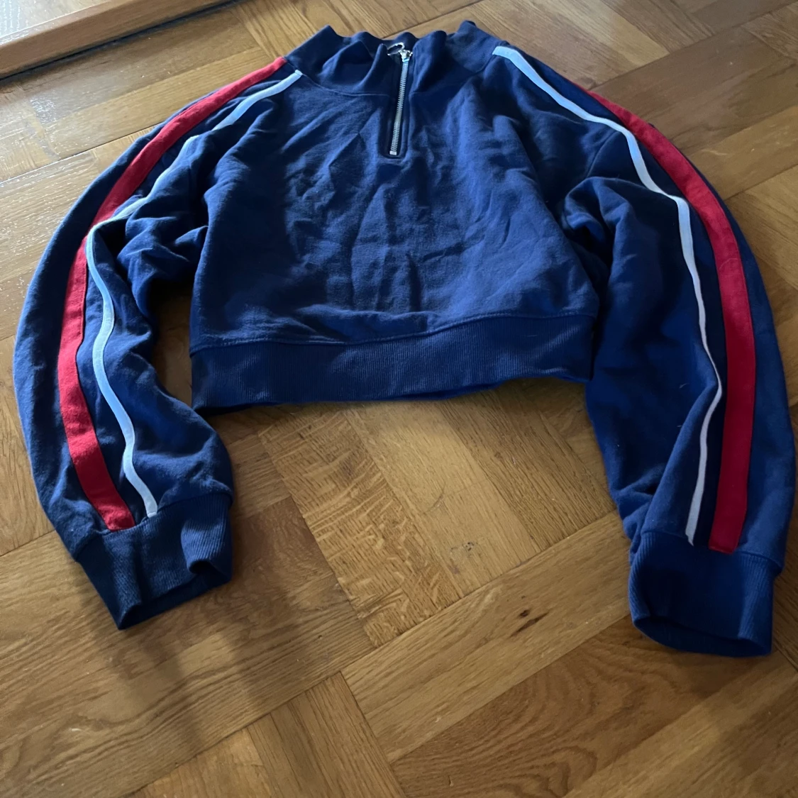Mörkblå sweatshirt med ränder på armarna