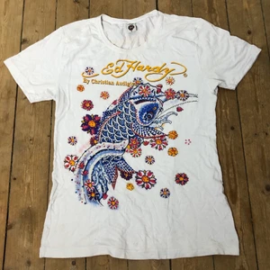 Ed hardy T-shirt  - En vit ed hardy T-shirt med gul text och ett stort tryck med massa rhinestones! Supermjukt material! 💖💖💖 står XL men skulle säga att den passar allt från XS-L beroende på hur man vill att den ska sitta!