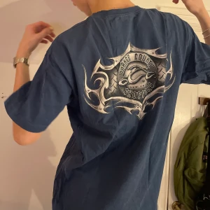 Vintage y2k cyber blå graphic tee silver - Blå oversized graphic tee med mindre silvrigt y2k tryck på bröstet och stort tryck på ryggen 🪙 det fetaste trycket som är så snyggt till silvriga smycken och ett par baggy jeans!