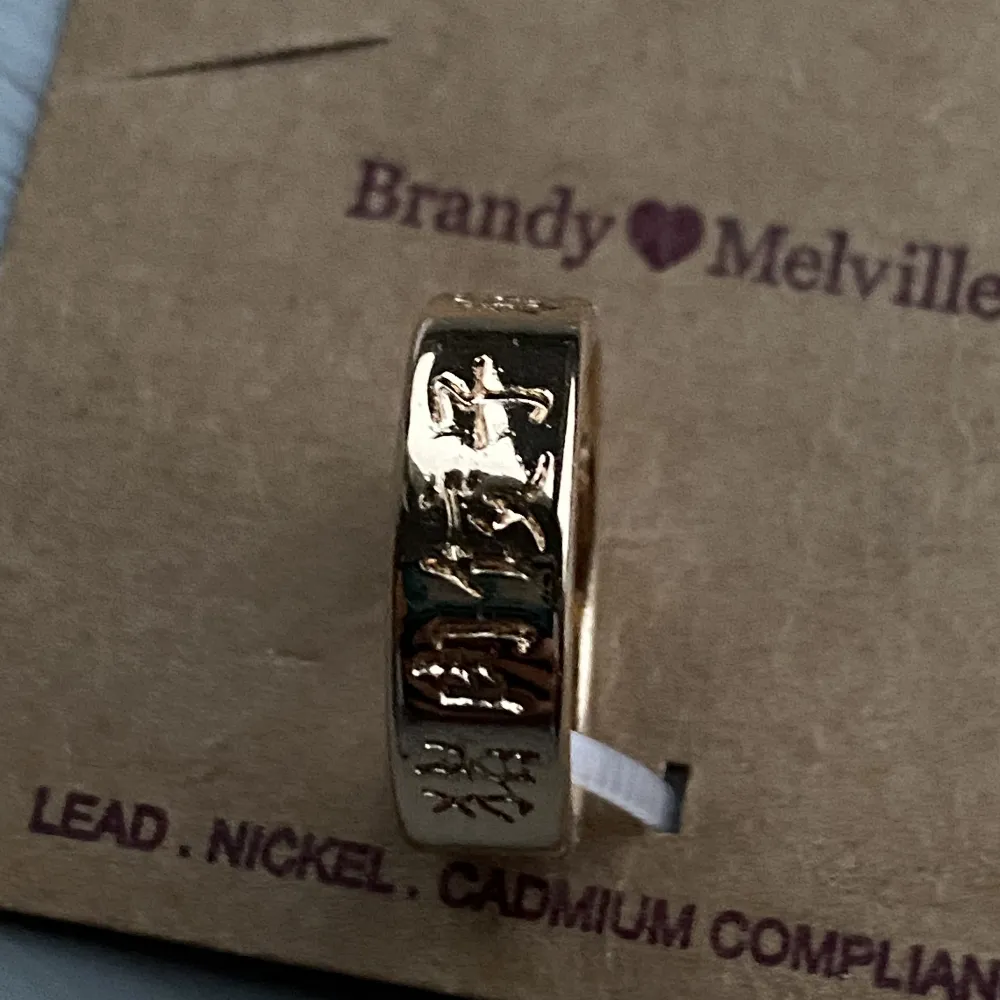 Helt ny guldig Brandy Melville ring med text på. Perfekt skick.. Accessoarer.