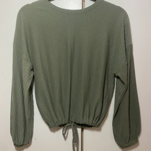 Grön tröja  - Aldrig använd. Lite mörkare grön tröja med band längst ner