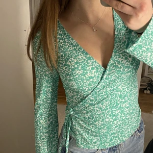 Topp Gina blus  - En super gullig grön och vit blus från Gina Tricot med en slags knytning , den har även ett ”lager” under. Super härlig aldrig använt, den har även lite vidare ärmar mot slutet som man kan se lite på bilden💘Dm för fler bilder eller frågor. Nypris 250kr❣️
