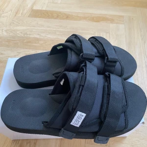 Suicoke Moto Sandaler - Suicoke sandaler i väldigt fint skick, ytterst små skrapmärken vid hälen och tårna men annars felfria. Storlek 44
