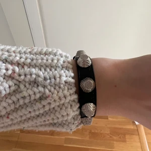 Balenciaga armband - Balenciaga armband i svart med silverdetaljer. Armbandet är i perfekt skick. 