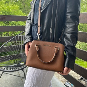 Michael Kors Handväska  - Brun Michael Kors handväska med gulddetaljer, rymmer allt! I jättebra skick! Kan skicka fler bilder på förfrågan. (Frakt ingår inte, kan dock mötas upp)