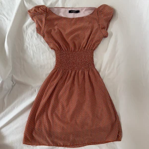 Orange kortärmad klänning - Söt orange klänning med fjärilsmönster som formar kroppen fint!  Visas på en s men passar säkert även m! Köpare står för 57kr spårbar frakt om inte funktionen ”köp nu” används. Plagget är i gott second hand skick. 