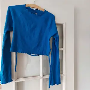 Open back tied blue shirt, long sleeved and length of a crop top - it says L but it's an S or M - perfect for summer evenings! 