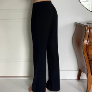 långa kostymbyxor - vida långa kostymbyxor. köpta second hand i strl 42, men har sedan sytt in dem så de passar mig som är en 36/38 i byxor. jag är 177cm och byxorna är långa på mig. färgen är navy/mörk marinblå, men ser svarta ut i vissa ljus. är osäker på märket, då det blivit bortklippt när jag sydde in dem. 