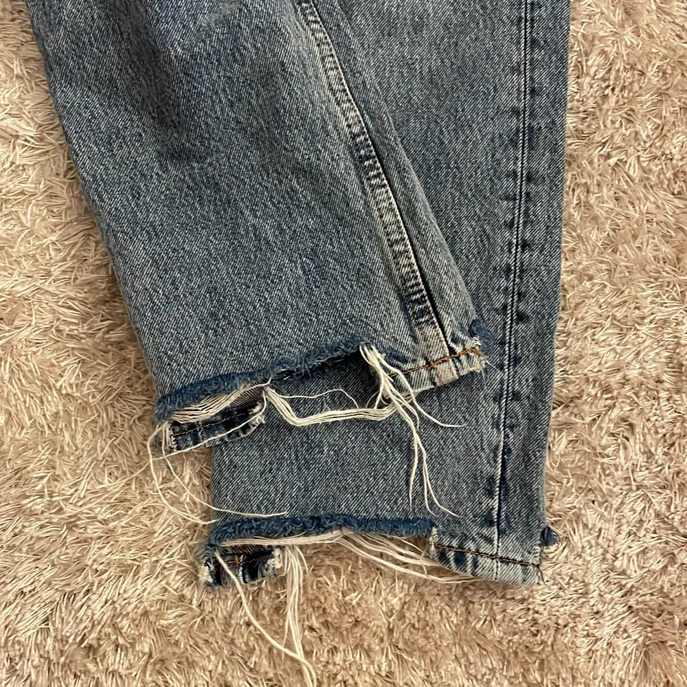 Jeans i en lite kallare blå färg, lågmidjade till medelhög midja, även slitna detaljer längst ner samt på ena bakfickan. Storlek small. Jeans & Byxor.