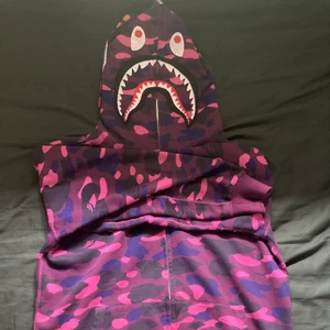 Purple bape shark hoodie - Skick 7/10, Knappt använd, Finns flera bilder. Helt äkta. Köpt helt ny 6500kr. Storlek large men passar perfekt på M (: