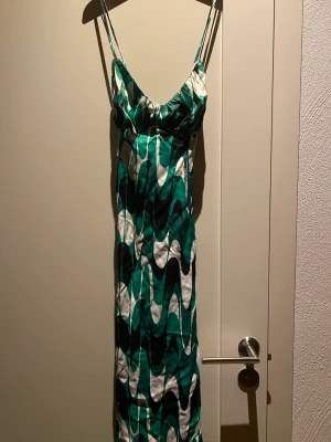 Klänning grön, svart  och vit  - En enkel klänning med band, snygg mönster.  Aldrig använd och prislapp sitter på. 
