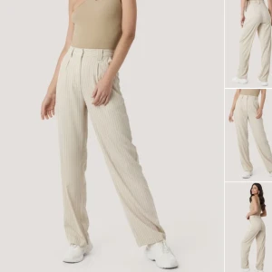 Beiga kritstrecksrandiga kostymbyxor - Fina kostymbyxor från nakd. Liten fläck på ena benet men syns knappt alls när de är på.  (Säljer samma modell i svart)