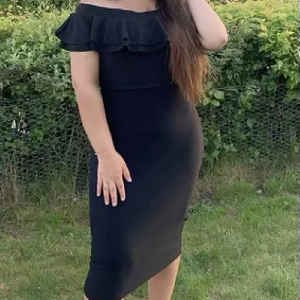 Jätte fin svart midi klänning i storlek M, endast använd en gång så det är fortfarande i ny skick. Klänningen är off shoulder med volanger och även i stretchig och mjuk material så den är även bekväm. Nypris 540kr.. Mekot.
