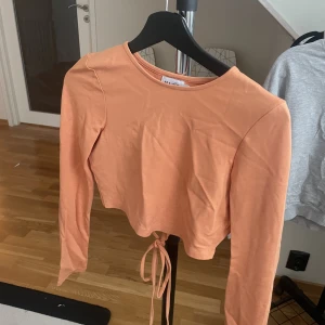 Orange topp - Säljer denna snygga topp med öppenrygg från NA-KD i storlek S! 🧡