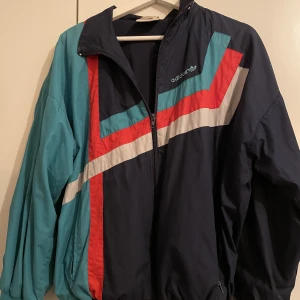 adidas jacka storlek S - Adidas jacka storlek S, blå/röd/grön. Ganska använd men inga större tecken på användning utan gott skick. Passar S och ganska normalt fit. 