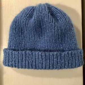 Stickad mössa  - Supermysig handstickad mössa i riktigt fin blå färg! Mössan är av alpacaull och merinoull som gör den både varm och mjuk (alltså noll sticksig). Passar på flesta huvudstorlekarna, unisex.  Tar emot beställning, går att få i andra färger 😊