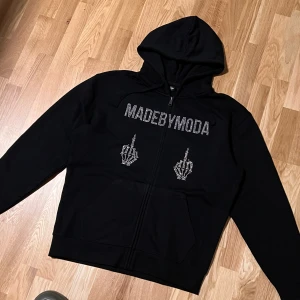 MADEBYMODA zip-up hoodie - Säljer min MADEBYMODA zipup hoodie. Väldigt tjockt material med rhinestone tryck. Använd ett fåtal gånger, 9/10 inga flaws. Köptes för 700kr säljs nu för 300kr