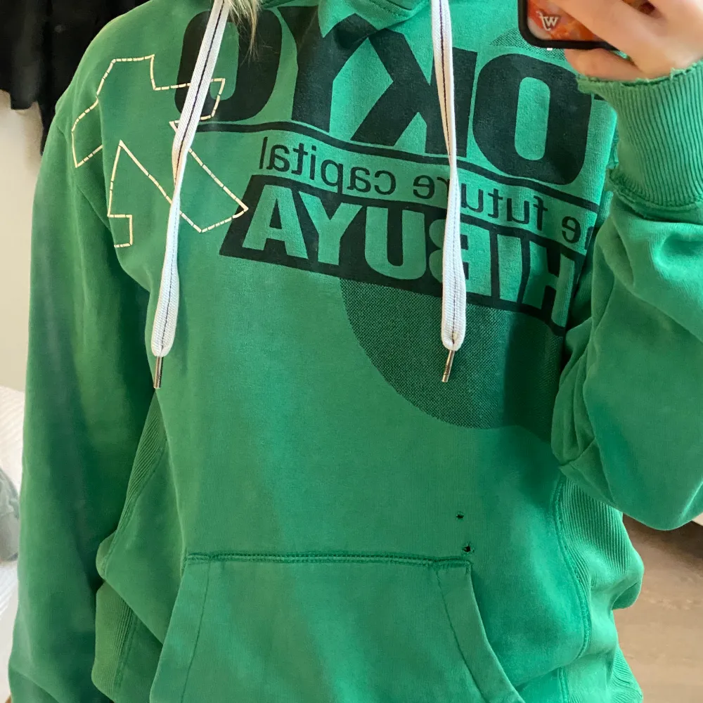 Säljer nu denna gröna hoodie med tryck. Tröjan är skitcool men kommer tyvärr inte till användning längre. Den är lite sliten men inget man tänker på. Står ingen storlek i tröjan men jag skulle gissa på M/L, sitter oversized på mig med S. Skriv vid frågor!❣️❣️. Tröjor & Koftor.