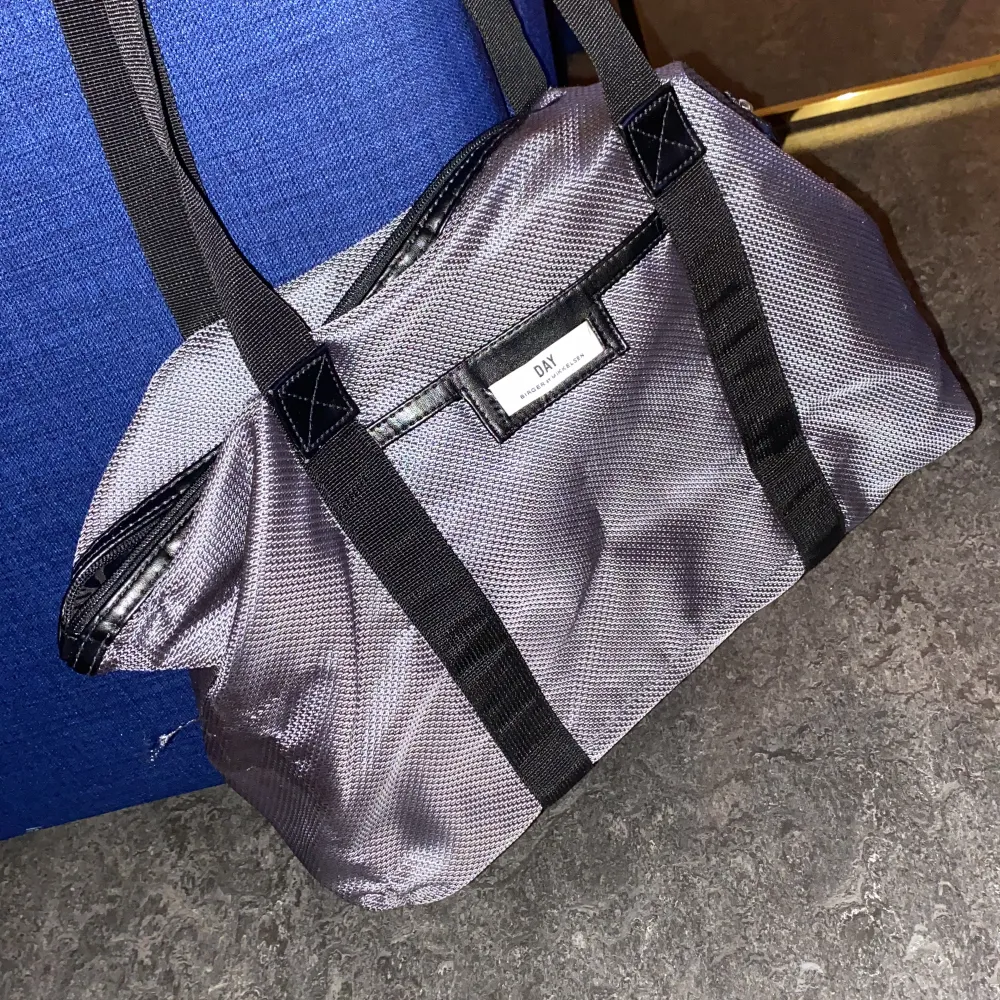 Silvrig väska nylon från DAY. Snygg till jobbet eller träningen. Använd men fortfarande i gott skick. . Väskor.
