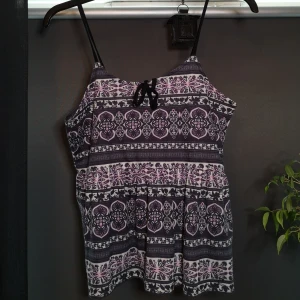 Linne  - Ett mönstrat lika linne med svarta band över axlarna. Det är lite resor ungefär i mitten för att den ska sitta kvar men det är inget som känns. Svarta snören i roset som en fin liten detalj. I ett bra skick😊