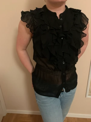 Volangblus svart från HM stl 40 - En fin svart fin volangblus från HM, stl 40.