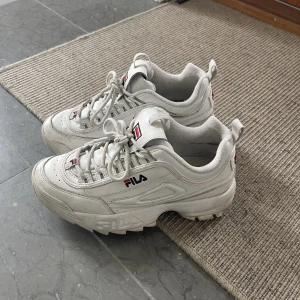Vita sneakers  - Vita sneakers från Fila i storlek 38. Har några få skador men inte så tydliga.