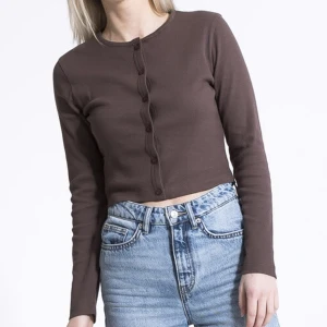 Cardigan  - Brun ribbad cardigan med knäppning. I nyskick.