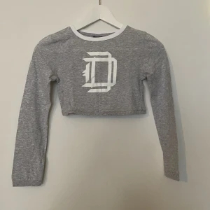 Drop Dead grå croppad långärmad tröja  - Drop Dead grå croppad långärmad tröja   Grå långärmad tröja med DD tryck   Väldigt croppad  Aldrig använd   Storlek petite 4 ( xs petite )