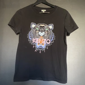 Kenzo T-Shirt ÄKTA - En fin Kenzo T-shirt i storlek M, passar S även då den är liten i storleken. Några enstaka fläckar men i övrigt i bra skick som går att se på bilderna.