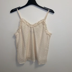 Vit Topp - En fin vit topp med volanger. Perfekt nu till sommarn och kan användas till en kjol eller jeans.