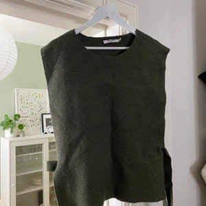 Stickad väst NA-KD - Stickad grön väst från NA-KD, men knyte i sidorna. Storlek L, men den passar både en M eller XL beroende på hur man vill att den ska sitta. Sparsamt använd, nypris 399:- mitt pris 150:-