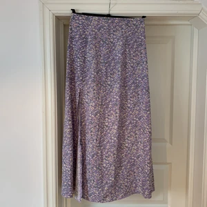 Lila SHEIN kjol, storlek S - En supersöt längre kjol från SHEIN i storlek S. Den är lila med vita blommor i mönstret. Nyskick.