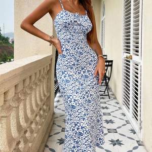 Jätte fin lång blå/vit klänning med blommigt mönster , den sitter tajt och smickrande runt kroppen!!, aldrig använd 