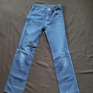 Vintage wranglerjenas i fint skick använt skick (har varit upplagda i byxslutet)  Midjemått: 78 cm Innerbenslängd 86 cm  Stumt i materialet. Passar inte mig som vanligtvis har W 27/28 i jeans.
