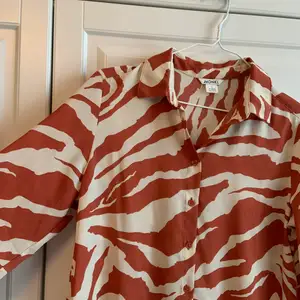 Skjorta från Monki med rostrött zebramönster. Knappt använd!  Strl S.  