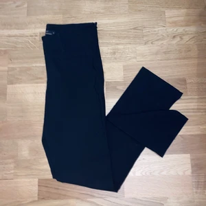 Kostymbyxor - Stretchiga kostymbyxor med normalhög midja. Dragkedja i sidan som knäppning och två fejkfickor fram. Använda två gånger. Strl 40