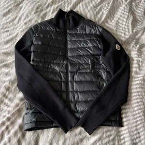 Moncler cardigan (Svart) - Säljer en schysst moncler cardigan i svart då den är för stor för mig. Super bra skick nästan aldrig använd, tyvärr finns det ingen garanti på om den är äkta eller inte… Så hör av dig vid minsta lilla fundering 😄 Storlek :M(2):